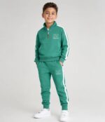 Băiat îmbrăcat într-un compleu sport verde mentă pentru copii, realizat din 90% bumbac și 10% elastan.