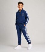 Băiat îmbrăcat într-un compleu sport albastru pentru copii, realizat din 90% bumbac și 10% elastan.