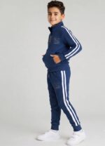 Băiat îmbrăcat într-un compleu sport albastru pentru copii, realizat din 90% bumbac și 10% elastan.